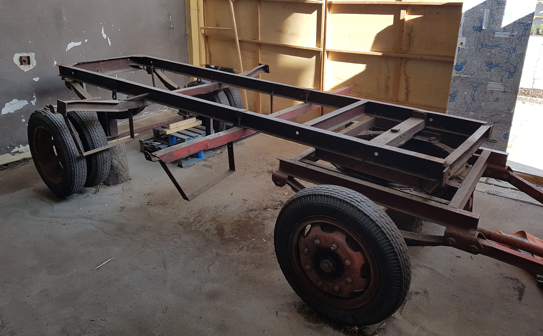 Das rostige Fahrgestell steht schräg vor einer Wand